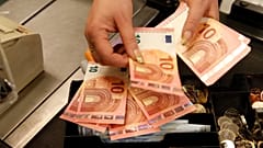 Kassierer überprüft Euro-Scheine vor der Eröffnung eines Geschäfts in Vilnius, Litauen, am Donnerstag, 1. Januar 2015.