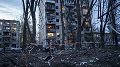 A woman with a dog walks among the rubble of a house damaged after a Russian strike on residential area in Kyiv, Ukraine, on Thursday, April 16, 2026.