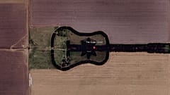 An aerial view of Estancia La Guitarra reveals a vast guitar-shaped forest planted with thousands of trees in Argentina.
