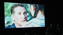 People watch a trailer for the upcoming film “As Deep as the Grave” featuring a character played by a generative AI version of Val Kilmer