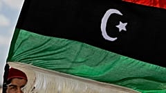 مقاتل ليبي متمرد يحمل علم المعارضة على مشارف أجدابيا بليبيا يوم الاثنين 18 أبريل 2011.