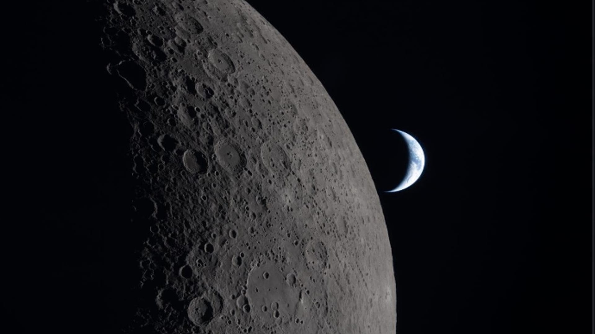 A superfície da lua e uma Terra em quarto crescente ao longe. 