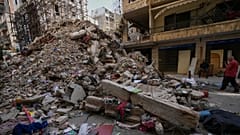 Anwohner stehen neben den Trümmern eines zerstörten Gebäudes, das vor einer Woche bei einem israelischen Luftangriff im Zentrum von Beirut, Libanon, getroffen wurde, Donnerstag, 16. April 2026