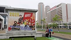 Pyongyang vatandaşları Pyongyang'da yeni inşa edilen Hwasong Bölgesi'nin bir caddesinde yürüyor, 15 Mayıs, 2025