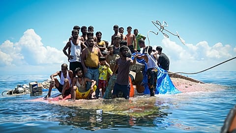 Rohingya-Flüchtlinge stehen auf ihrem gekenterten Boot, während Retter ihnen vor West-Aceh ein Seil zuwerfen, 21. März, 2024