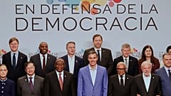 Spaniens Regierungschef Pedro Sánchez im hellen Anzug posiert am 18. April in Barcelona mit Teilnehmern des Demokratiegipfels.