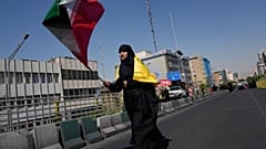 Una mujer ondea la bandera iraní durante una concentración organizada por el Estado en apoyo del líder supremo.
