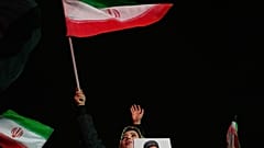امرأة تلوح بالعلم الإيراني وتحمل صورة المرشد الأعلى الإيراني الراحل آية الله علي خامنئي خلال تجمع مؤيد للحكومة في ساحة غرب طهران.