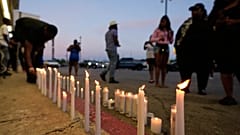 A man lights a candle during a prayer vigil for the victims of a mass shooting earlier in the day in Shreveport, 19 April, 2026