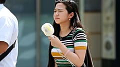 Uma mulher segura uma ventoinha portátil em Tóquio, na segunda-feira, 23 de julho de 2018, numa altura em que se prevêem temperaturas escaldantes em vastas áreas do Japão e da Coreia do Sul, numa onda de calor prolongada.