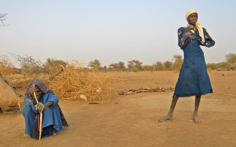 Una mujer y su nieta en su refugio rudimentario tras huir de los combates en Darfur (2004)
