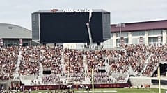 A skydiver hangs from his parachute after crashing into the scoreboard at Lane Stadium in Blacksburg, Virginia.