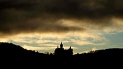 Das Schloss Wernigerode hebt sich am frühen Samstagmorgen, dem 11. Januar 2025, vor dem Harzwald in Deutschland als Silhouette ab.