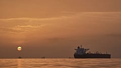 Ο ήλιος ανατέλλει πίσω από δεξαμενόπλοια που είναι αγκυροβολημένα στο Στενό του Ορμούζ στα ανοικτά της ακτής του νησιού Qeshm, 18 Απριλίου 2026