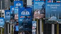 A police officer walks past billboards near the Serena Hotel ahead of the second round of negotiations between the US and Iran in Islamabad, 21 April, 2026 