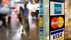 Sur cette photo d'archive du 23 juillet 2007, des panneaux indiquant les cartes de crédit American Express, Master Card et Visa sont apposés sur la porte d'un magasin new-yorkais.