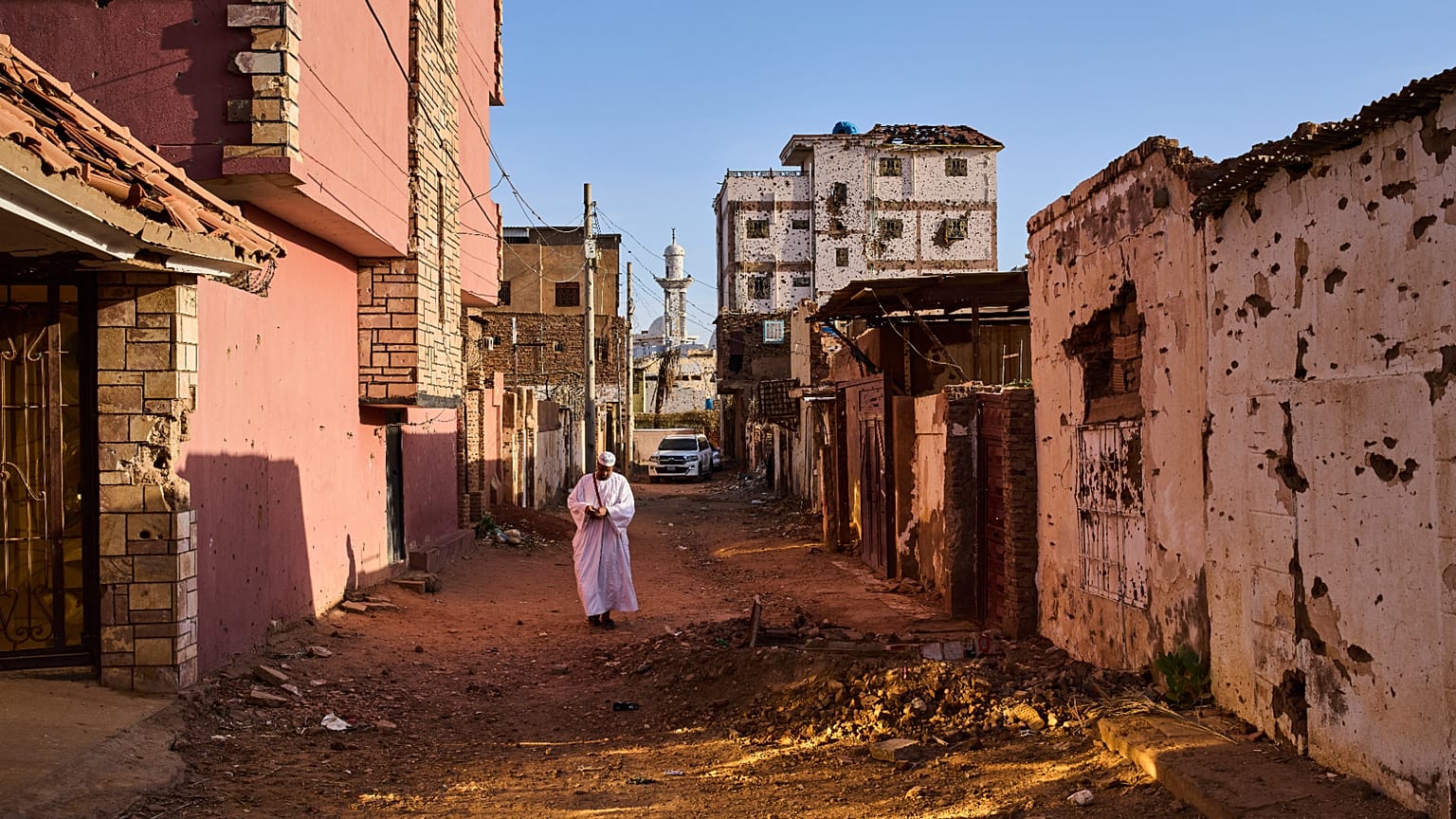 رجل يسير في شارع تضرر خلال الحرب في أم درمان بالسودان على مشارف الخرطوم، الجمعة 17 أبريل 2026. (AP Photo/بيرنات أرمانجو)