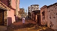 رجل يسير في شارع تضرر خلال الحرب في أم درمان بالسودان على مشارف الخرطوم، الجمعة 17 أبريل 2026. (AP Photo/بيرنات أرمانجو)