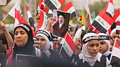 عراقی‌ها در بغداد با تصویری از مجتبی خامنه‌ای در جریان اعتراض به حملات آمریکا و اسرائیل به ایران، پنجشنبه، ۱۲ مارس ۲۰۲۶ 