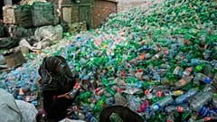 A worker sorts through empty bottles at a plastic recycling factory in Lahore, Pakistan, Aug. 7, 2025.