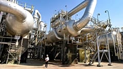 ARQUIVO - Um trabalhador caminha entre as instalações da refinaria de petróleo de Tengiz, no Cazaquistão, a 30 de agosto de 2004