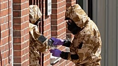 Askeri koruyucu giysiler içindeki acil durum çalışanları, Salisbury'deki Rollestone Caddesi'nde evsizlerin kaldığı çitlerle çevrili John Baker Evi'nde arama yapıyor, 6 Temmuz 2018