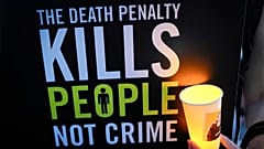 Ein Aktivist hält eine Kerze und ein Plakat während einer Mahnwache gegen die Todesstrafe vor der Botschaft von Singapur in Kuala Lumpur, 19. Februar 2025