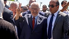 زعيم حزب النهضة راشد الغنوشي يوقع لافتة لدى وصوله إلى وحدة مكافحة الإرهاب في تونس العاصمة، يوم الثلاثاء 19 يوليو/تموز 2022. (صورة من وكالة أسوشييتد برس/حسن دريدي)