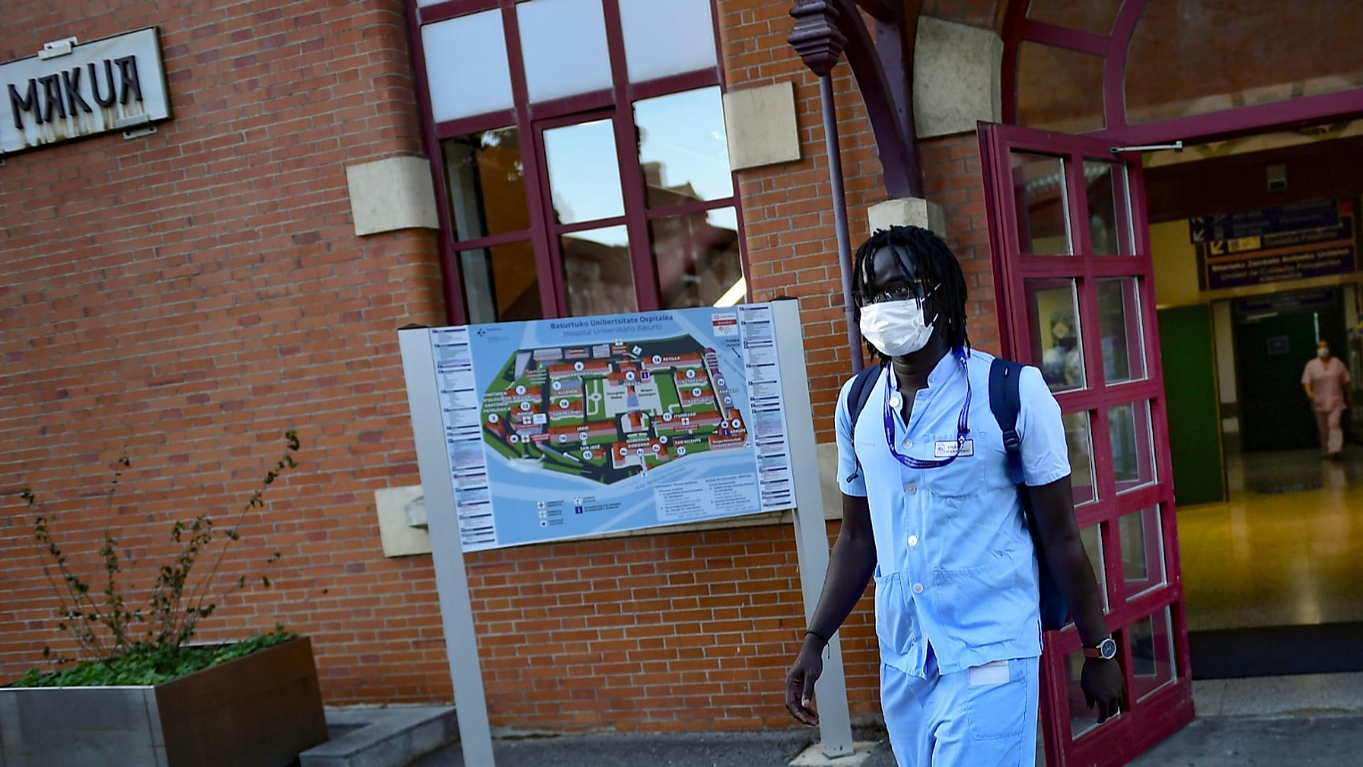 Mbaye Baacar Diouf, de 33 años, vestido con su uniforme de enfermero, camina por el hospital Basurto, en Bilbao, al norte de España, el 18 de noviembre de 2020.