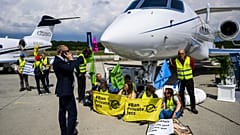 Activists of Stay Grounded and Greenpeace demonstrate while handcuffing themselves to a plane during the European Business Aviation Convention. Switzerland, May, 2023.
