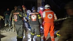 متطوعون من الصليب الأحمر اللبناني وعمال الدفاع المدني وهم يحملون جثة الصحفية اللبنانية أمل خليل العاملة في صحيفة الأخبار اليومية