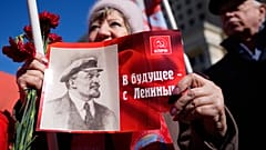 Eine Frau hält ein Transparent mit einem Porträt von Wladimir Lenin und dem Slogan "Mit Lenin in die Zukunft".