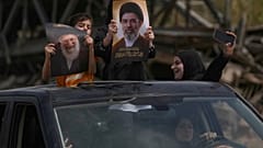 أطفال نازحون يحملون صور المرشد الأعلى الإيراني الراحل آية الله علي خامنئي وابنه المرشد الحالي آية الله مجتبى خامنئي