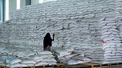 ARCHIVO - Una trabajadora camina junto a una pila de sacos de alimentos en un almacén del Programa Mundial de Alimentos (PMA) en Semera.