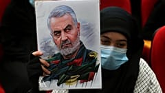 امرأة تحمل صورة قائد فيلق القدس الإيراني قاسم سليماني، الذي قُتل في غارة أمريكية بطائرة بدون طيار في بغداد.