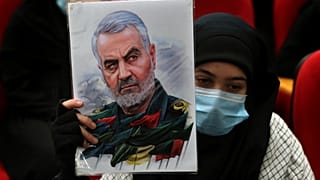 امرأة تحمل صورة قائد فيلق القدس الإيراني قاسم سليماني، الذي قُتل في غارة أمريكية بطائرة بدون طيار في بغداد.