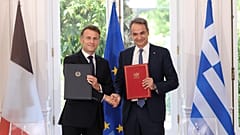 El apretón de manos entre Mitsotakis y Macron con el acuerdo firmado en la mano
