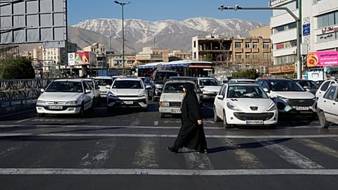 Una mujer cruza una calle en Teherán, Irán, el jueves 26 de febrero de 2026. (AP Photo/Vahid Salemi)