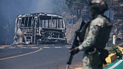 FILE: A soldier stands guard by a charred vehicle after it was set on fire, in Cointzio, Michoacán state, Mexico, 22 February 2026
