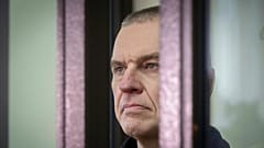 Journalist Andrzej Poczobut stands in a defendants' cage in court in Grodno, 16 January, 2023