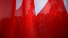 يظهر في الصورة بحرينيون عاطلون عن العمل ومؤيدوهم، وهم يرفعون أعلام بلادهم أمام وزارة العمل في مدينة عيسى، البحرين، يوم الخميس 1 مايو/أيار 2014.