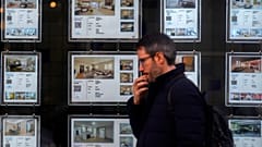 Ein Mann geht am Dienstag, 14. Januar 2025, an einem Büro einer Immobilienagentur vorbei, die Wohnungen in Madrid, Spanien, bewirbt.