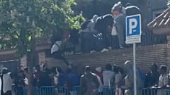 Personas saltan una valla para entrar en la Embajada de Gambia.