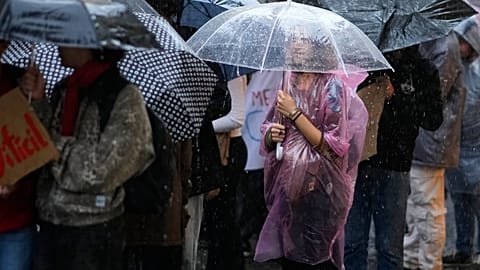 Estudiantes que protestan contra el aumento de las tasas académicas se refugian bajo paraguas durante una fuerte lluvia en Lisboa, el martes 28 de octubre de 2025.