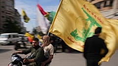 رجال يركبون دراجة نارية وهم يلوحون بعلم حزب الله خلال تجمع صغير في الضاحية الجنوبية لبيروت، لبنان، السبت 25 أبريل 2026.