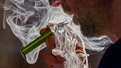 رجل يدخن سيجارة إلكترونية للاستخدام مرة واحدة في بروكسل في 12 ديسمبر 2024،
