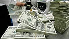 Un impiegato di banca sudcoreano lavora accanto a mazzette di dollari USA nella sede centrale della Korea Exchange Bank a Seul, il 20 ottobre 2008.