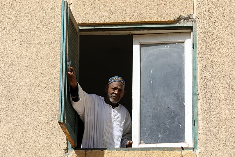 A Sudanese refugee looks out from his apartment in 6 October City, Egypt