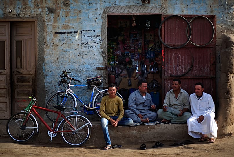 FILE: Palestinian refugees sit in front of a bicycle repair shop in Gezirat al-Fadel village, Sharqiya, about 150 kilometres east of Cairo, 17 May 2013