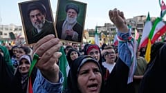 امرأة تحمل صورة المرشد الأعلى الإيراني الجديد مجتبى خامنئي وصورة والده الراحل علي خامنئي الأربعاء 29 أبريل 2026